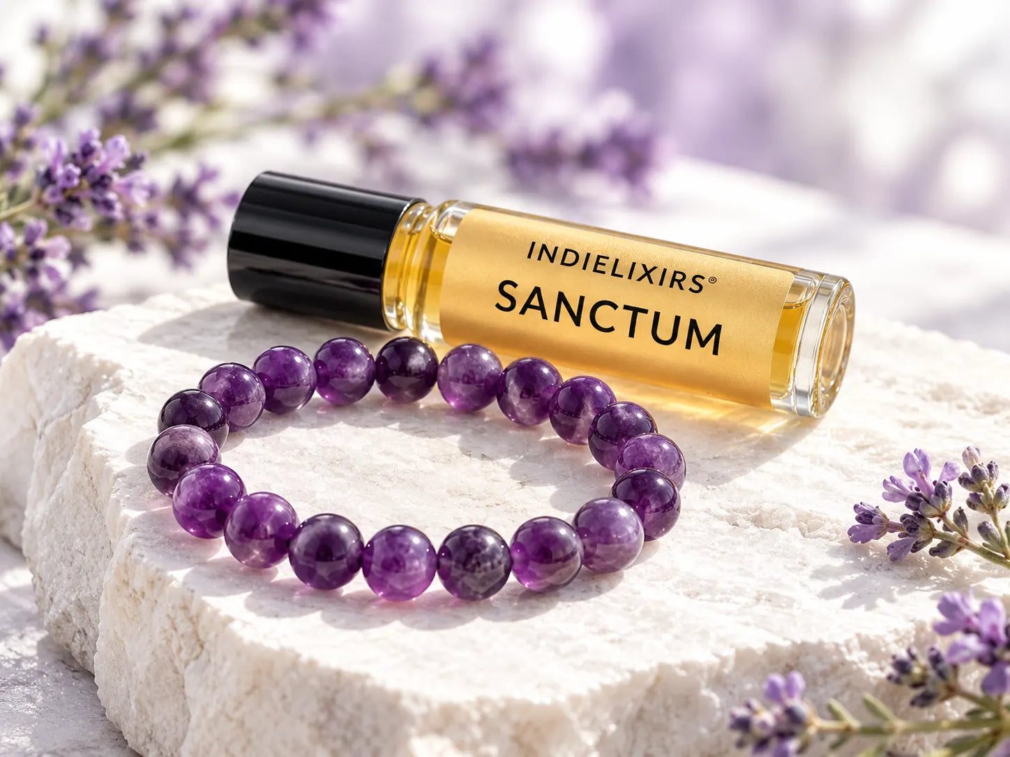 SANCTUM aromatic roller beside a polished purple Amethyst bracelet on pale stone with lavender sprigs