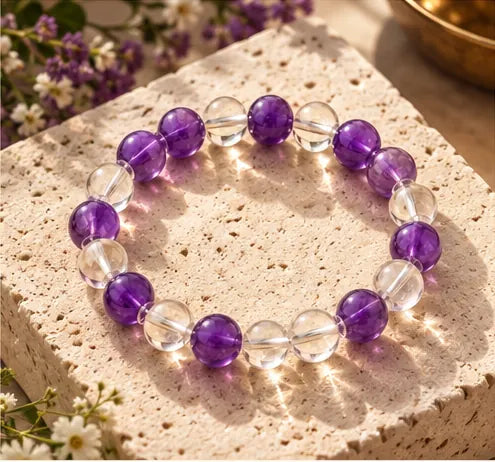 Purple amethyst and clear quartz bracelet on an ivory stone slab