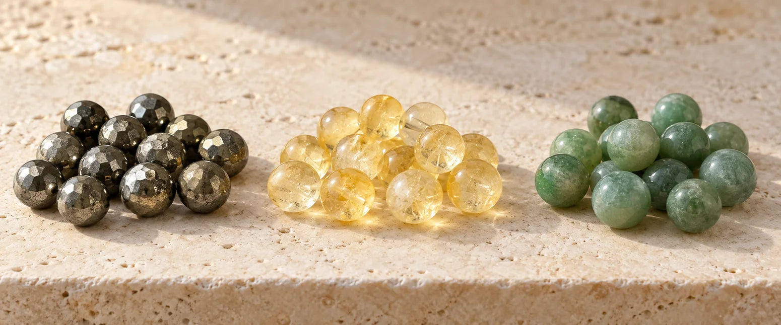 Three groups of metallic grey pyrite, pale yellow citrine and green aventurine beads
